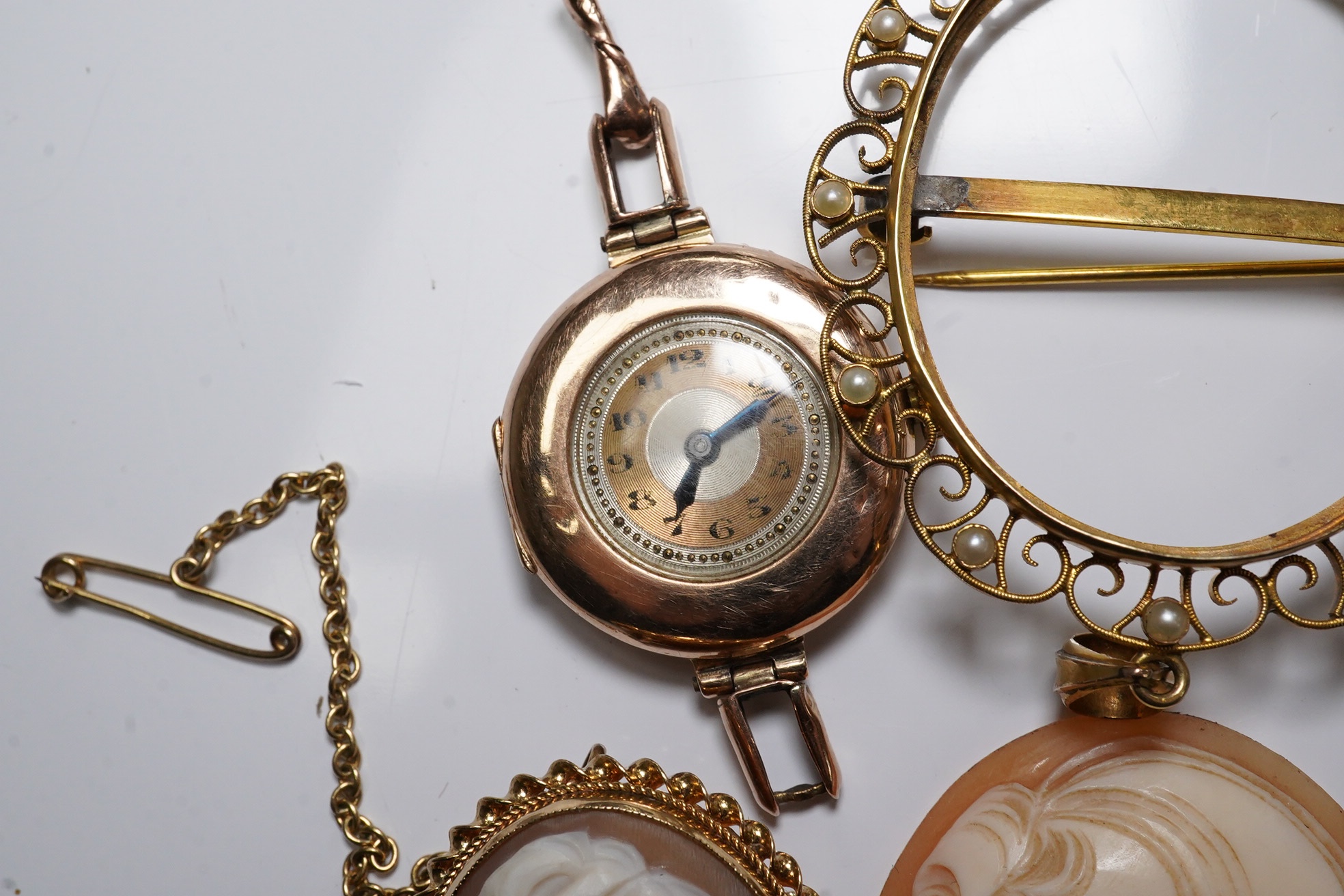 Three carved oval cameo shells, including tow in 9ct pendant or brooch mount, a 9ct gold wrist watch (a.f.) and a stick pin. Condition - poor to fair